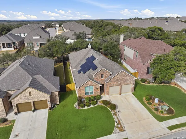an aerial view of a house with garden space and a car park