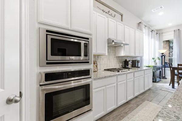 a kitchen with cabinets stainless steel appliances and a sink
