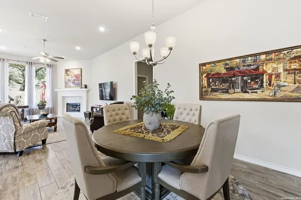 a view of a dining room with furniture a chandelier and wooden floor