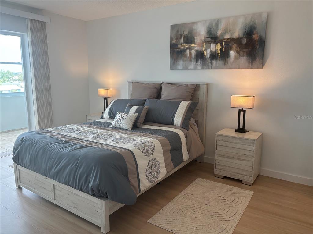 4725 Cove Circle, Unit 405 St. Petersburg, FL 33708 - Photo 8 of 23 a bedroom with a bed and lamp
