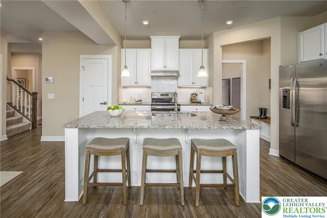 a kitchen with stainless steel appliances granite countertop a kitchen island hardwood floor and a sink