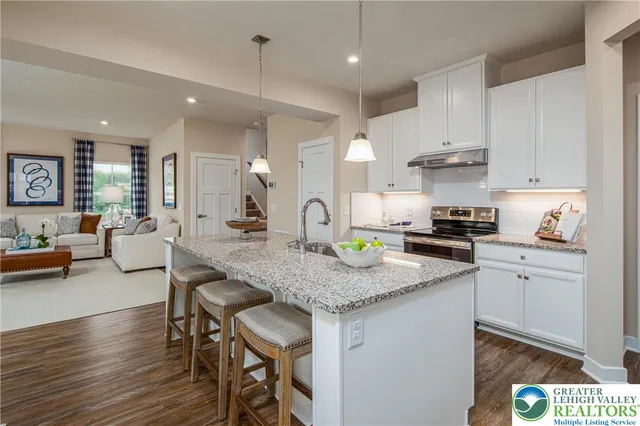 a kitchen with granite countertop a table chairs stove a sink and cabinets