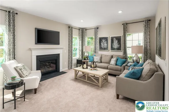 a living room with furniture a flat screen tv and a fireplace