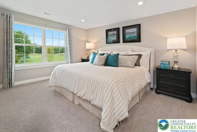 a spacious bedroom with a bed and a large window