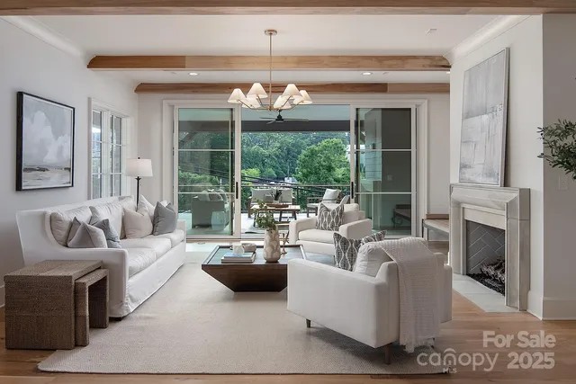 a living room with furniture a fireplace and a chandelier