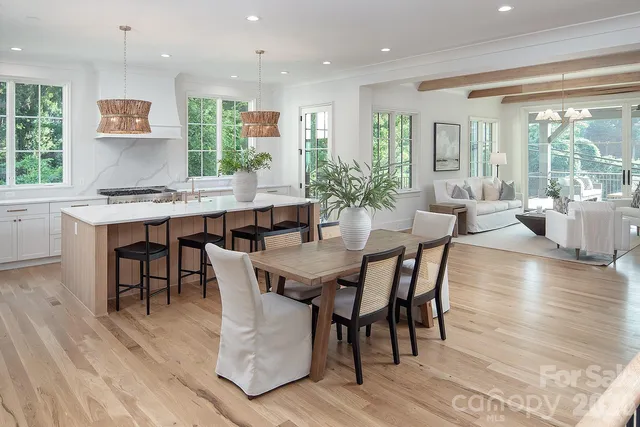 a kitchen with stainless steel appliances a dining table chairs and window