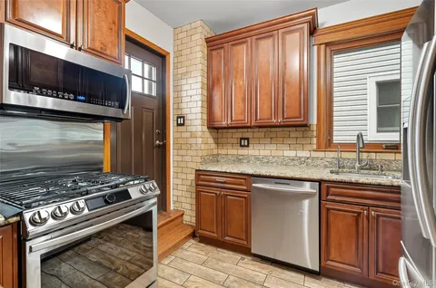 a kitchen with stainless steel appliances granite countertop a stove and a microwave
