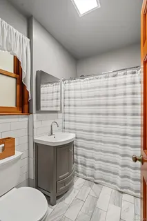 a bathroom with a sink a toilet and mirror