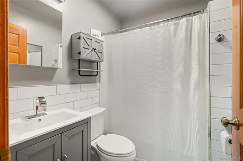 a bathroom with a sink a toilet and shower curtain