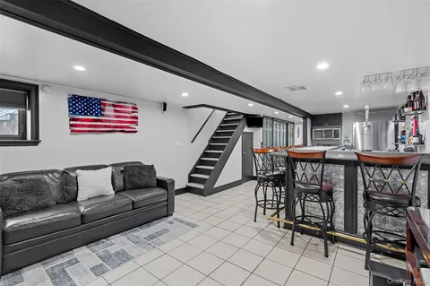 a living room with furniture a piano and a bookshelf