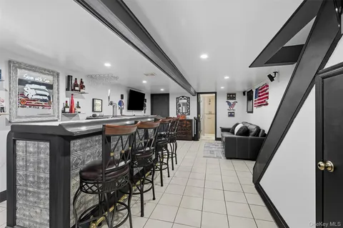a living room with stainless steel appliances furniture a rug and a large window