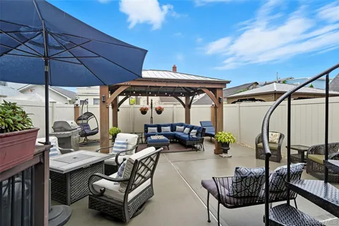 a view of patio with table and chairs under an umbrella