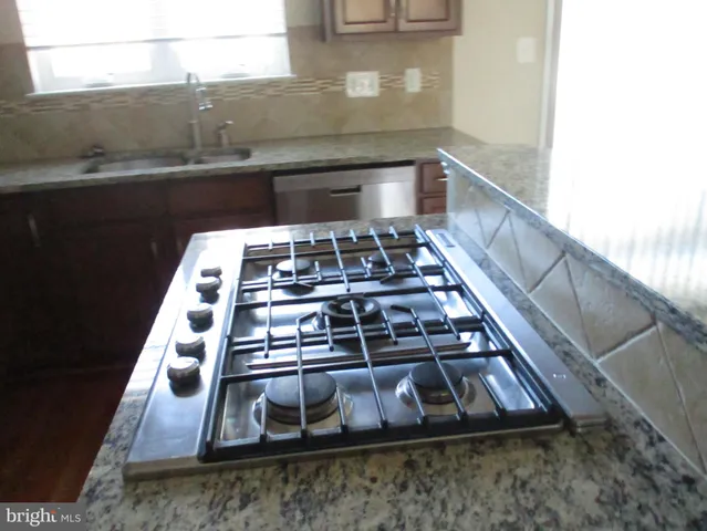 a kitchen with kitchen island a refrigerator and a sink
