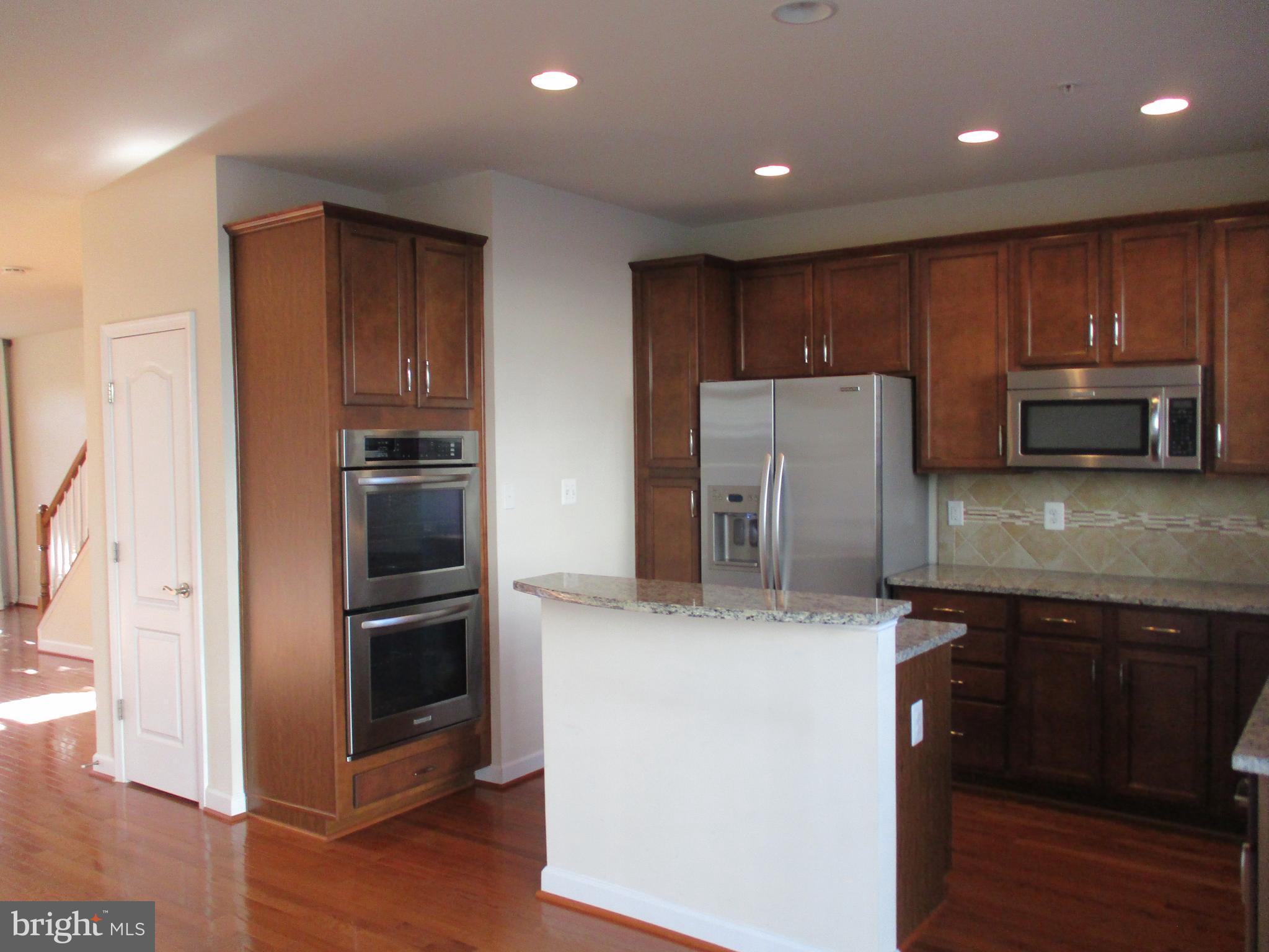 2144 Little Sorrel Way Silver Spring, MD 20902 - Photo 13 of 31 a kitchen with kitchen island a refrigerator and a sink