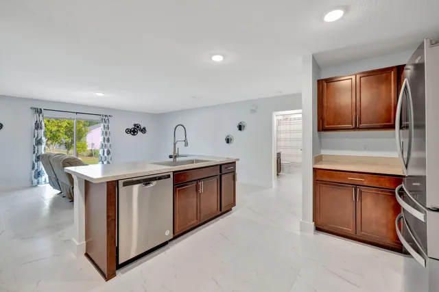 a kitchen with stainless steel appliances granite countertop a stove a sink and a refrigerator