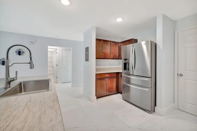 a kitchen with stainless steel appliances granite countertop a refrigerator and a sink