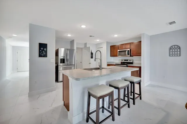 a kitchen with kitchen island a sink stove and refrigerator