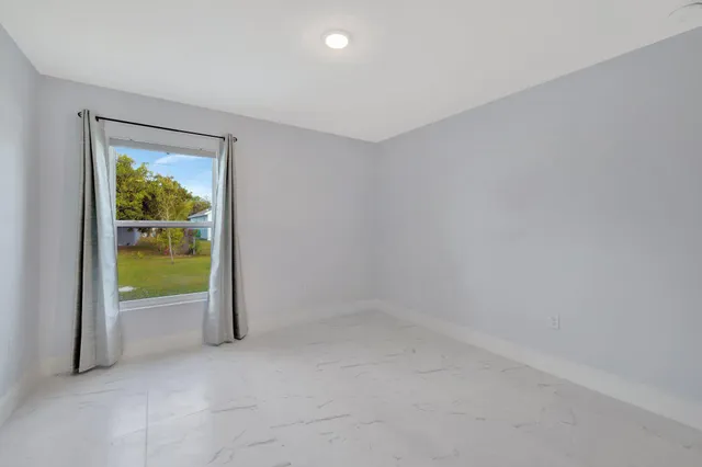 an empty room with a door and windows