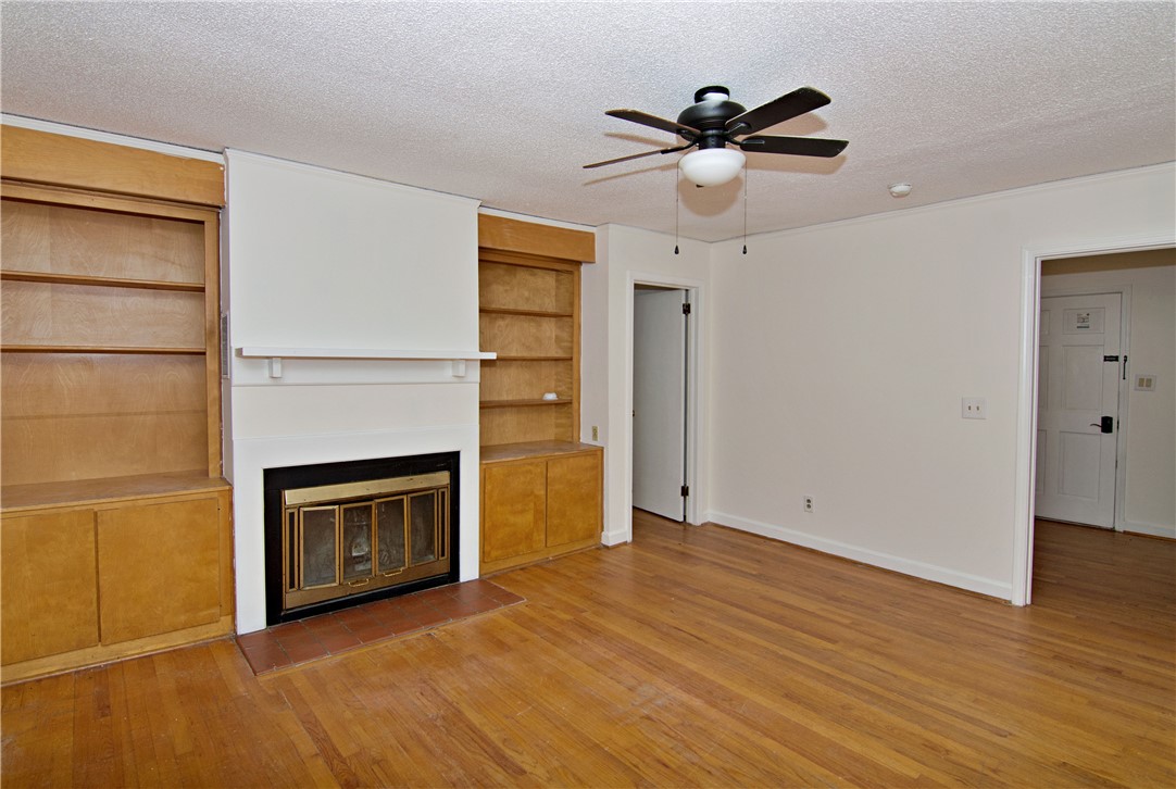 102 Broad Street Clemson, SC 29631 - Photo 15 of 40 A well-lit living space features hardwood floors, a cozy fireplace, and built-in shelving.