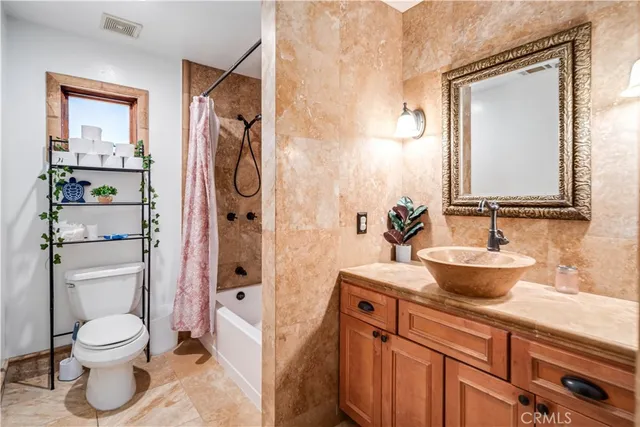 a bathroom with a granite countertop sink a toilet and shower
