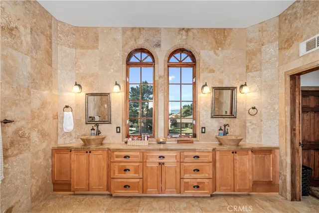 a spacious bathroom with double vanity and a mirror