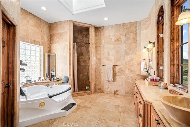 a bathroom with a tub sink and mirror