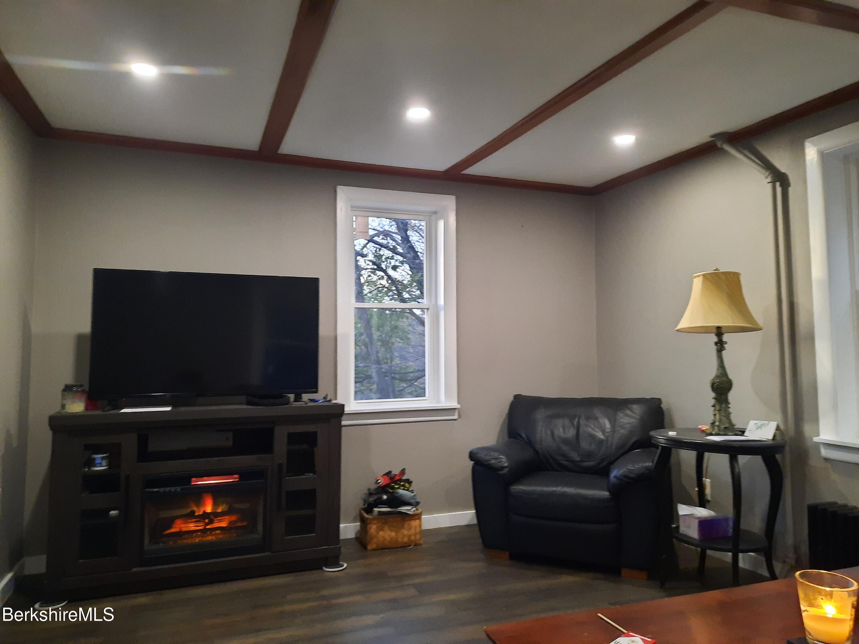 910 Daniels Road Clarksburg, MA 01247 - Photo 29 of 41 a living room with furniture a flat screen tv and a fireplace