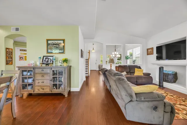 a dining room with stainless steel appliances kitchen island granite countertop a table chairs and a large window