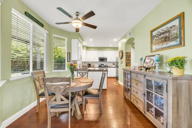 a kitchen with a stove a sink a counter top space and living room view