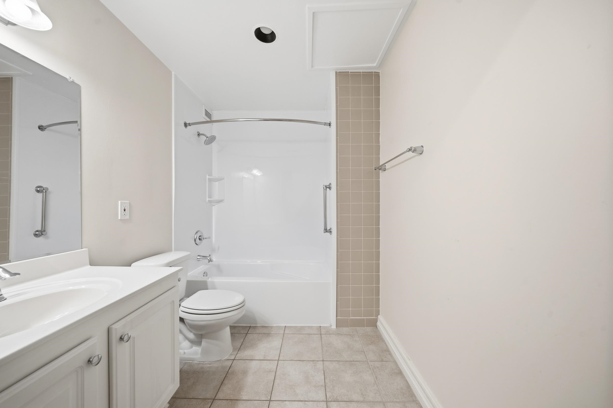 655 Riverside Drive, Unit 205A Memphis, TN 38103 - Photo 10 of 24 a bathroom with a granite countertop sink a toilet and shower