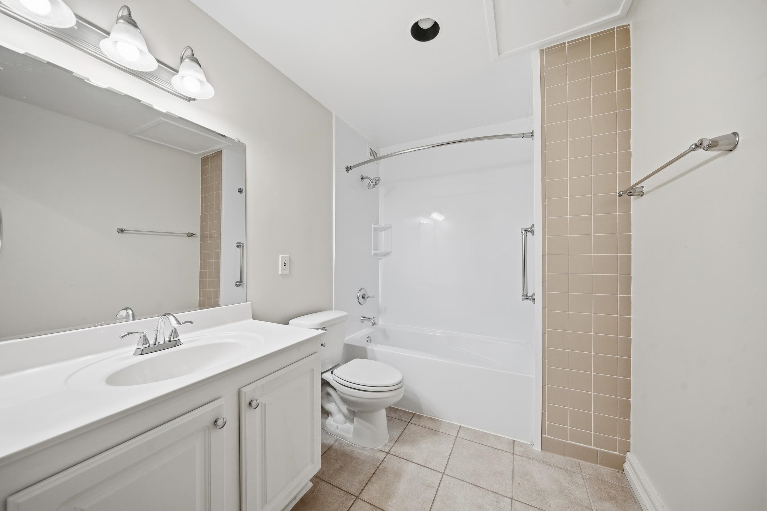655 Riverside Drive, Unit 205A Memphis, TN 38103 - Photo 9 of 24 a bathroom with a double vanity sink toilet and shower