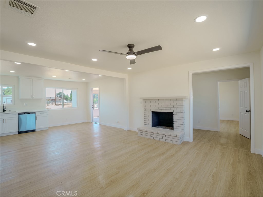 21865 Fox Apple Valley, CA 92307 - Photo 5 of 27 an empty room with wooden floor fireplace and windows