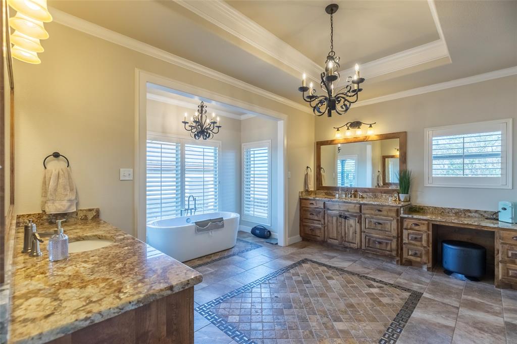 126 Phoenix Lane Tuscola, TX 79562 - Photo 25 of 40 a large spacious bathroom with a granite countertop sink a large mirror and a bathtub