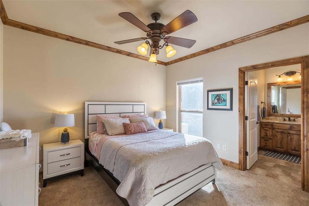 126 Phoenix Lane Tuscola, TX 79562 - Photo 29 of 40 a bedroom with a bed and a chandelier