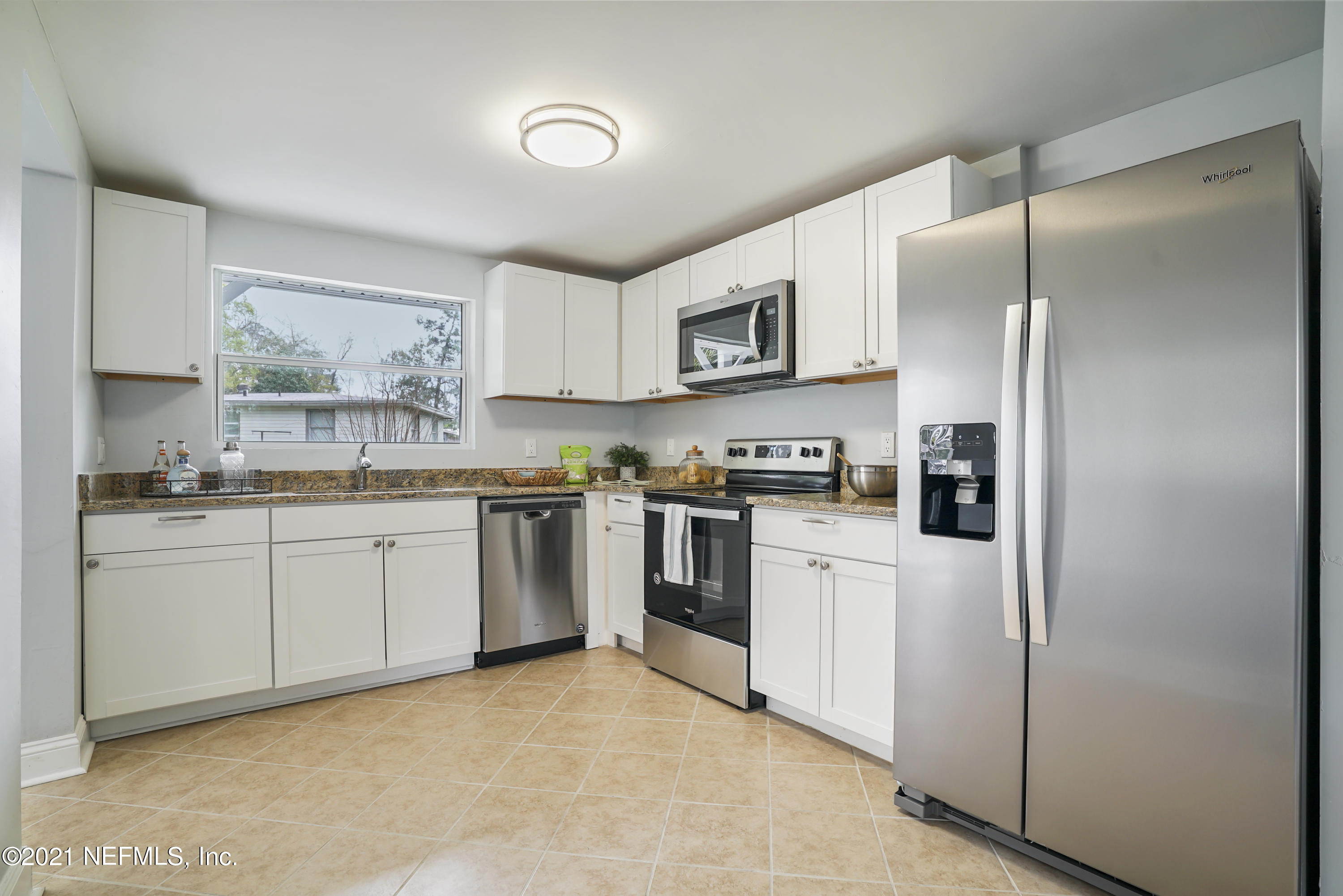 4175 Spring Glen Road Jacksonville, FL 32207 - Photo 2 of 25 a kitchen with white cabinets and stainless steel appliances