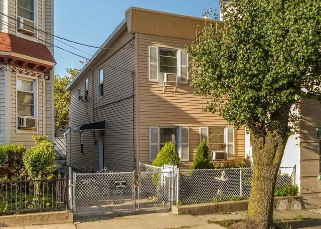 a front view of a house with a tree