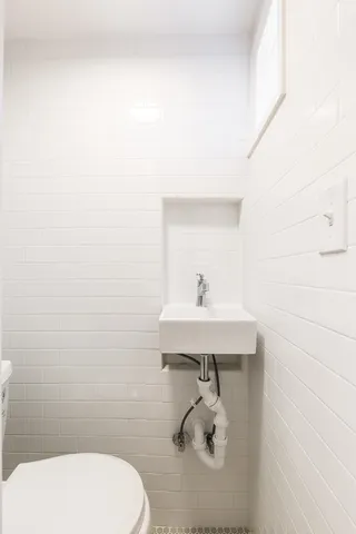 a bathroom with a sink a toilet and mirror