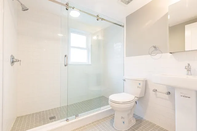 a bathroom with a toilet sink and a mirror