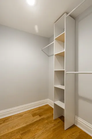 a view of an empty room with empty room and wooden floor