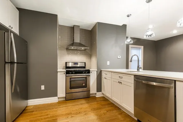 a kitchen with stainless steel appliances granite countertop a refrigerator sink and stove