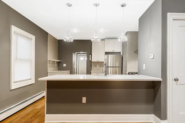a kitchen with kitchen island sink and refrigerator