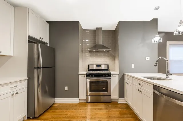 a kitchen with stainless steel appliances granite countertop a refrigerator and a stove