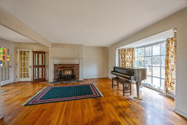 a living room with furniture a fireplace and wooden floor