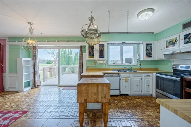 a kitchen with granite countertop a stove a sink and a refrigerator