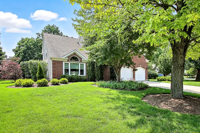a front view of a house with a yard and trees