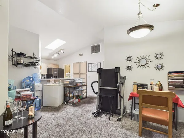 a room with furniture a flat screen tv and a refrigerator