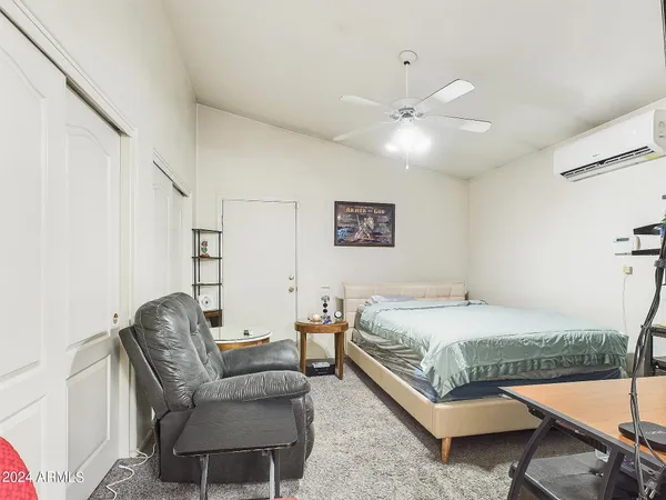 a bedroom with a bed couch and a window