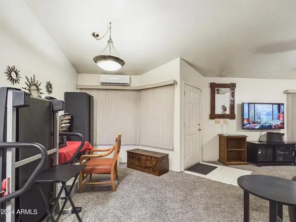 a living room with furniture a piano and a flat screen tv