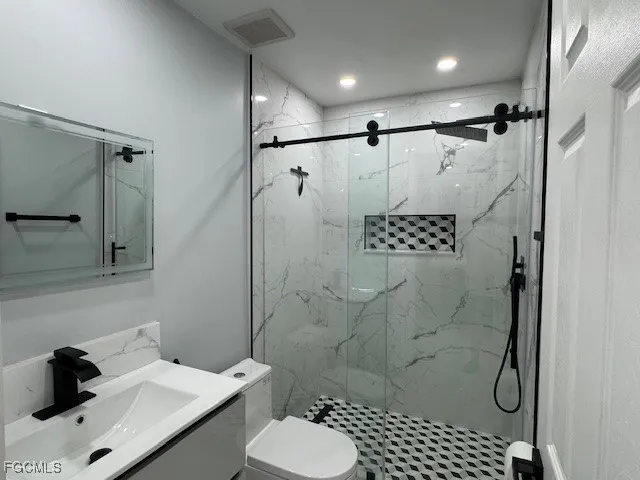 a bathroom with a shower toilet and sink