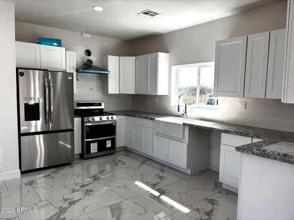 a kitchen with a sink a refrigerator and a stove top oven